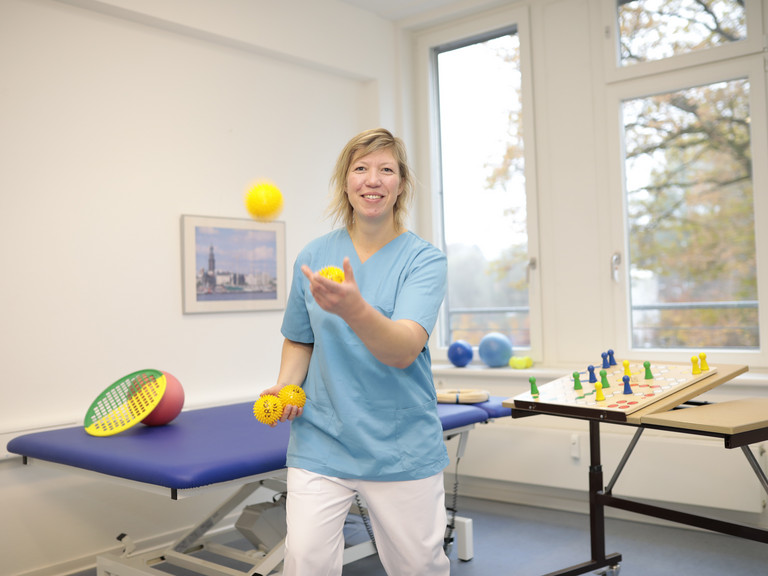 Eine Mitarbeiterin jongliert mit drei gelben Bällen, Angebot, Leistungen, Geriatrie & Physikalische Medizin, Frührehabilitation, Evangelisches Amalie Sieveking Krankenhaus, Hamburg-Volksdorf Eine Mitarbeiterin jongliert mit drei gelben Bällen, Angebot, Leistungen, Geriatrie & Physikalische Medizin, Frührehabilitation, Evangelisches Amalie Sieveking Krankenhaus, Hamburg-Volksdorf
