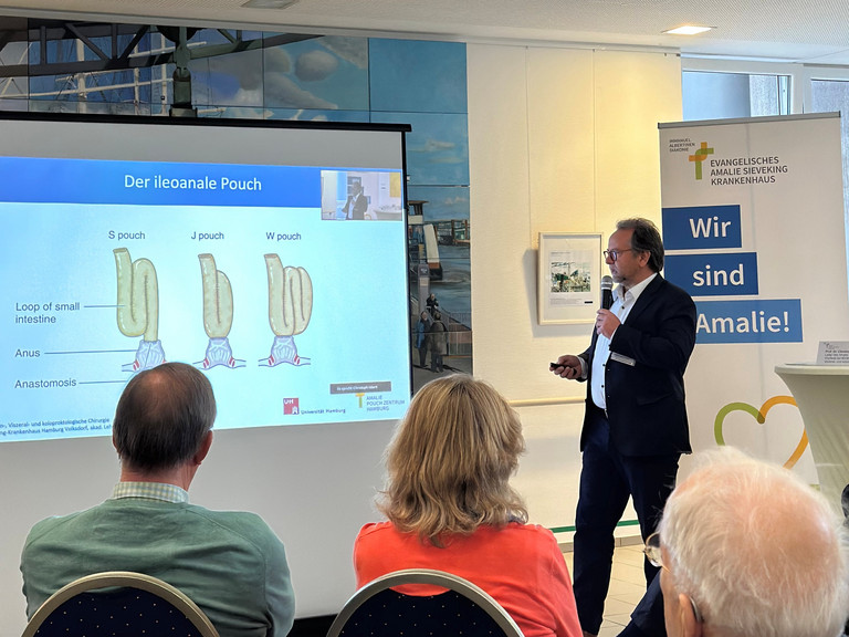 Ein Arzt hält eine Präsentation im Zuge des Arzt-Patienten-Seminars im Amalie Pouch Zentrum Hamburg Ein Arzt hält eine Präsentation im Zuge des Arzt-Patienten-Seminars im Amalie Pouch Zentrum Hamburg
